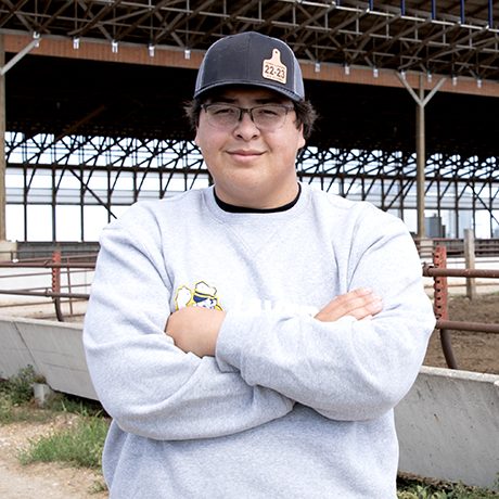Iowa Lakes Community College Ag student in front of feed lot.