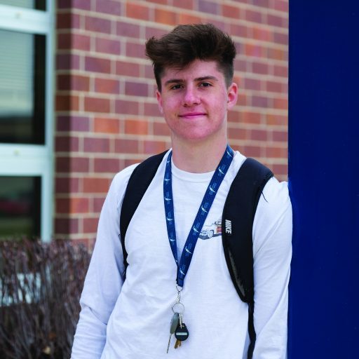 Business Administration student outside by blue pillar